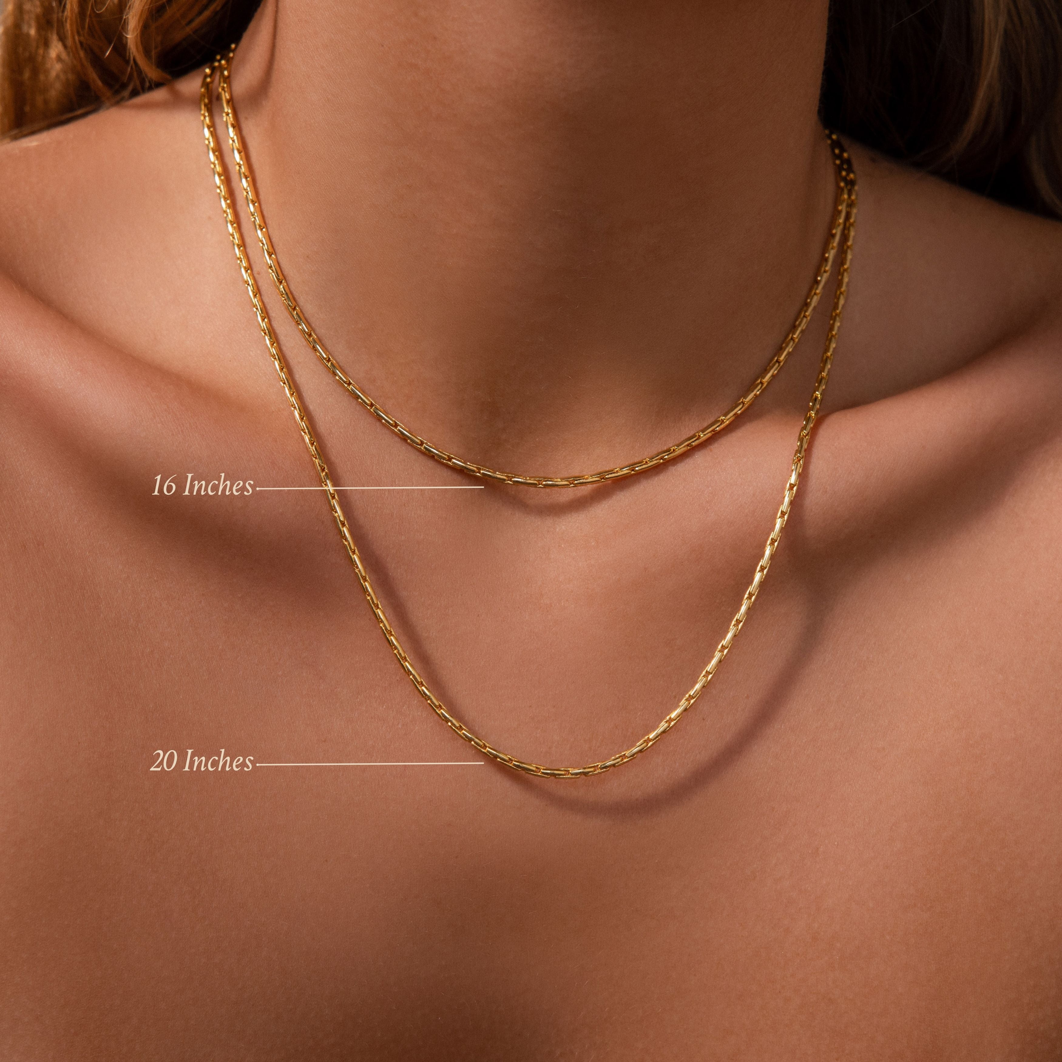 A woman wears two Bold Link Chain Necklaces in 16 and 20, showing how the modern chain lengths create a striking statement look.