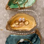 Twisted Pearl Hoops displayed on colorful oyster shells and crushed ice.