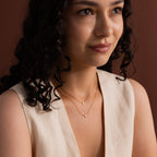 Model wearing two dainty gold cross charm necklaces in 16 and 18 inches.