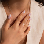 Model wearing a dainty silver cross charm necklace.