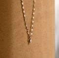 Dainty Marquise Pendant Necklace in Silver with a mirror twist chain, displayed elegantly against a speckled, light brown cylindrical surface.