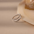Chelsea Duo Ring in silver with rope and smooth band design styled against a shell accent.