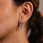 Close-up of a woman’s ear wearing Twisted Link Earrings in White Gold—these modern earrings feature a unique design that adds timeless elegance to any look.