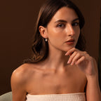 A woman with long brown hair poses with her hand near her chin, wearing a strapless top and the Diamond Pearl Droplet Earrings in Sterling Silver.