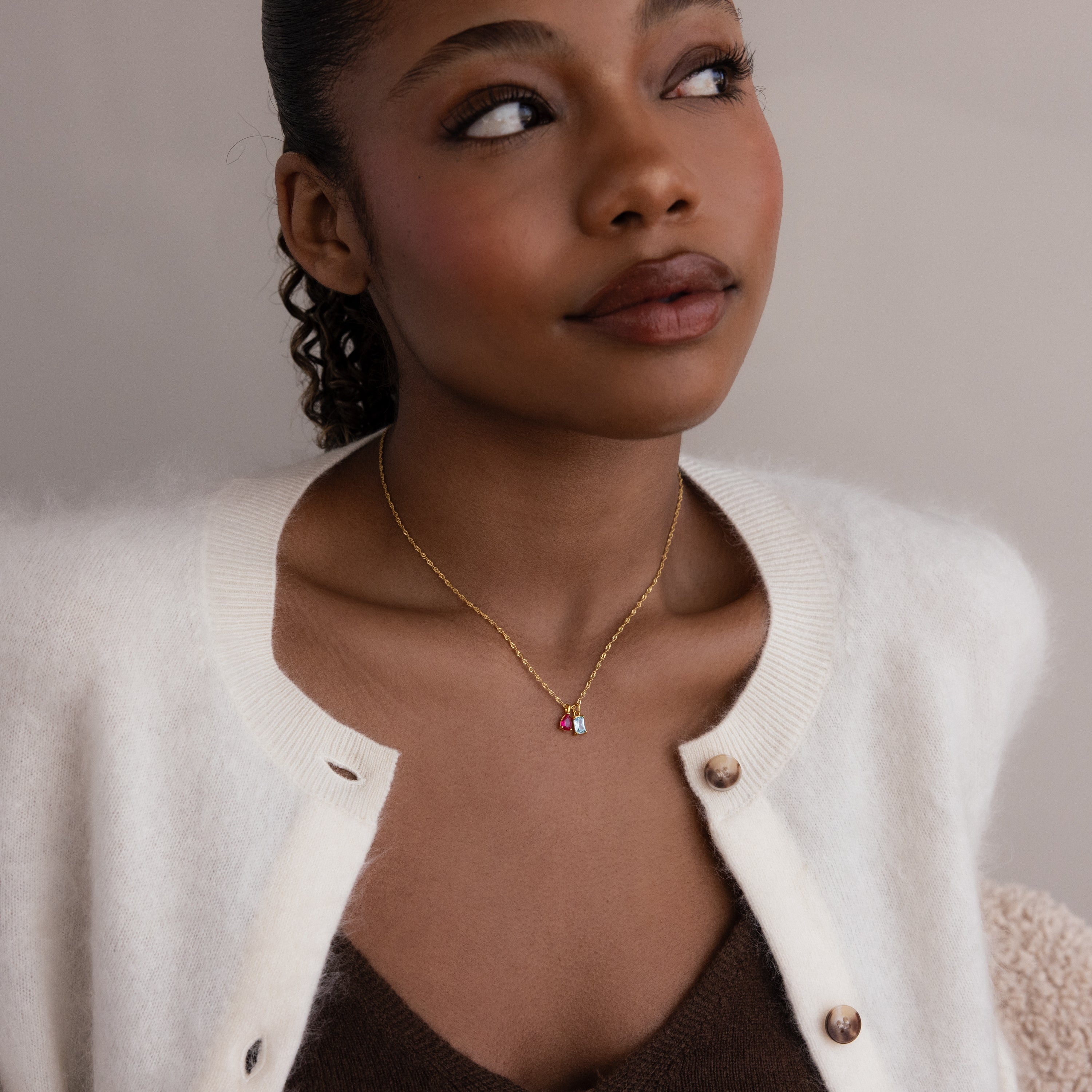 Model wearing a gold Singapore Twist Necklace with Pear & Baguette Birthstone Charm Set