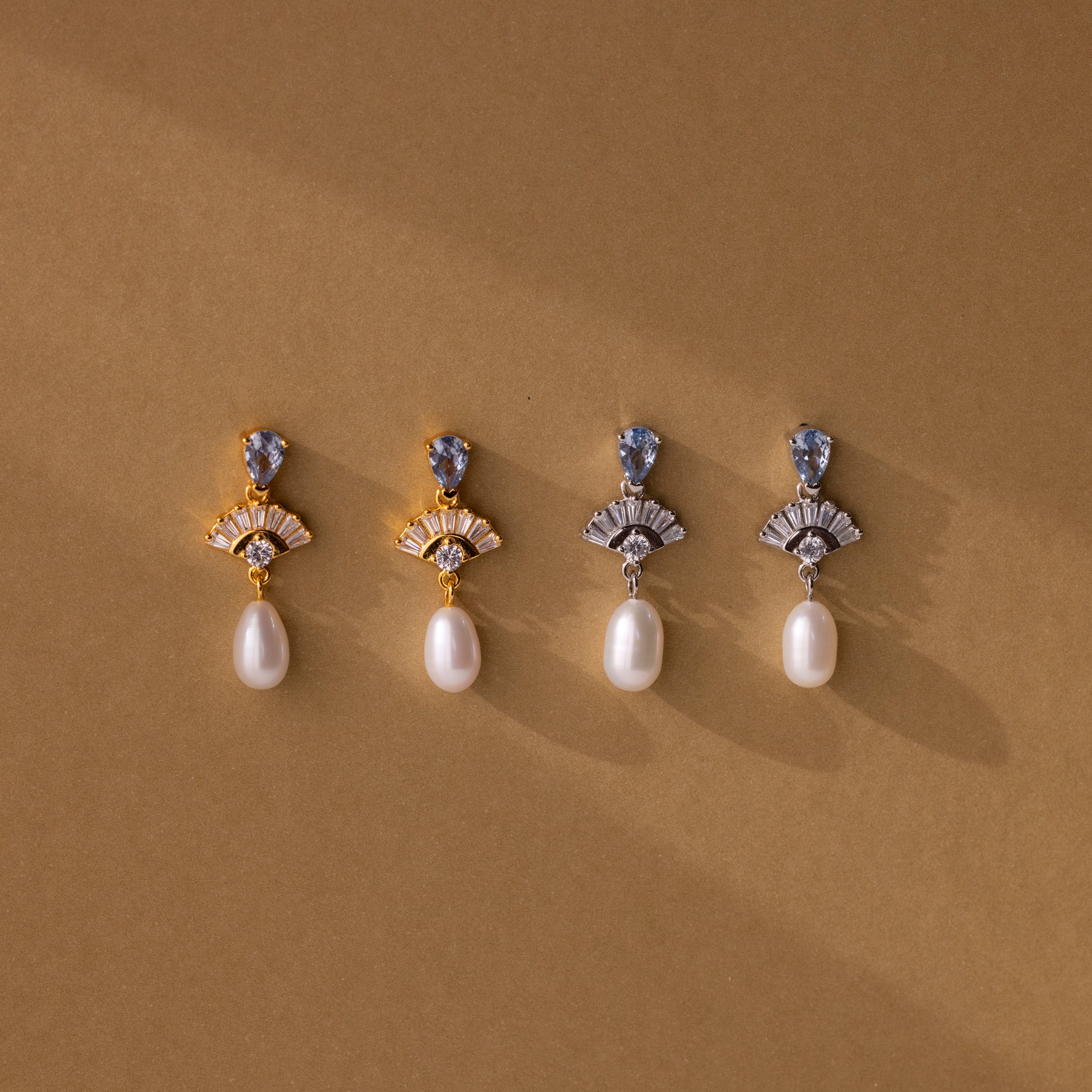 Four Aquamarine Pearl Drop Earrings in 18K Gold displayed on a brown background with soft shadows—perfect wedding earrings that embody timeless vintage glamour.