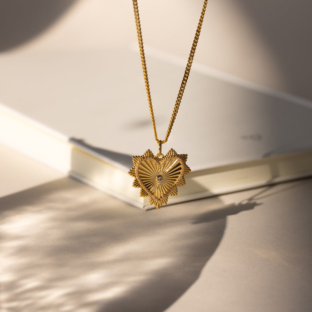 Gold Ribbed Diamond Heart Charm hanging from chain