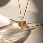 Gold Ribbed Diamond Heart Charm hanging from chain