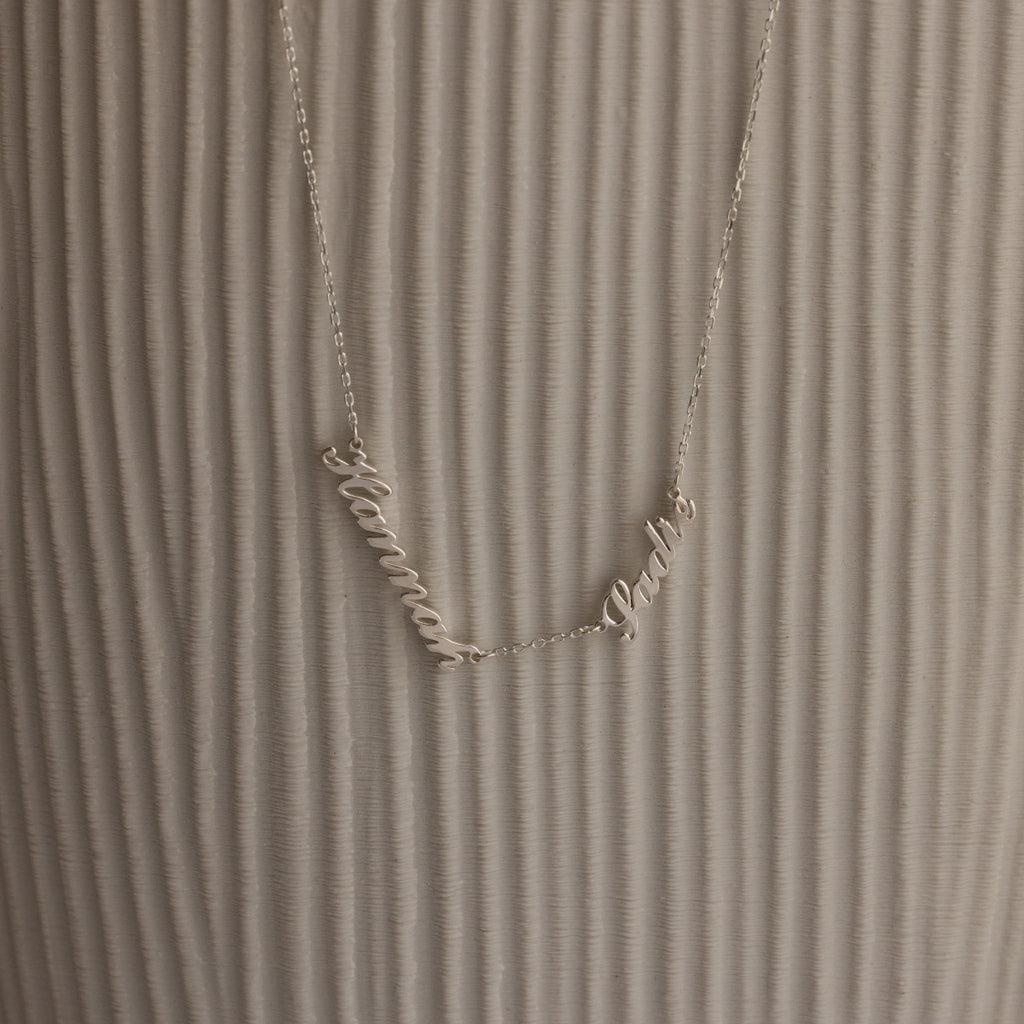 Carrie Multiple Name Necklace with Hanna and Pablo on a textured, light background—a perfect personalized jewelry piece.
