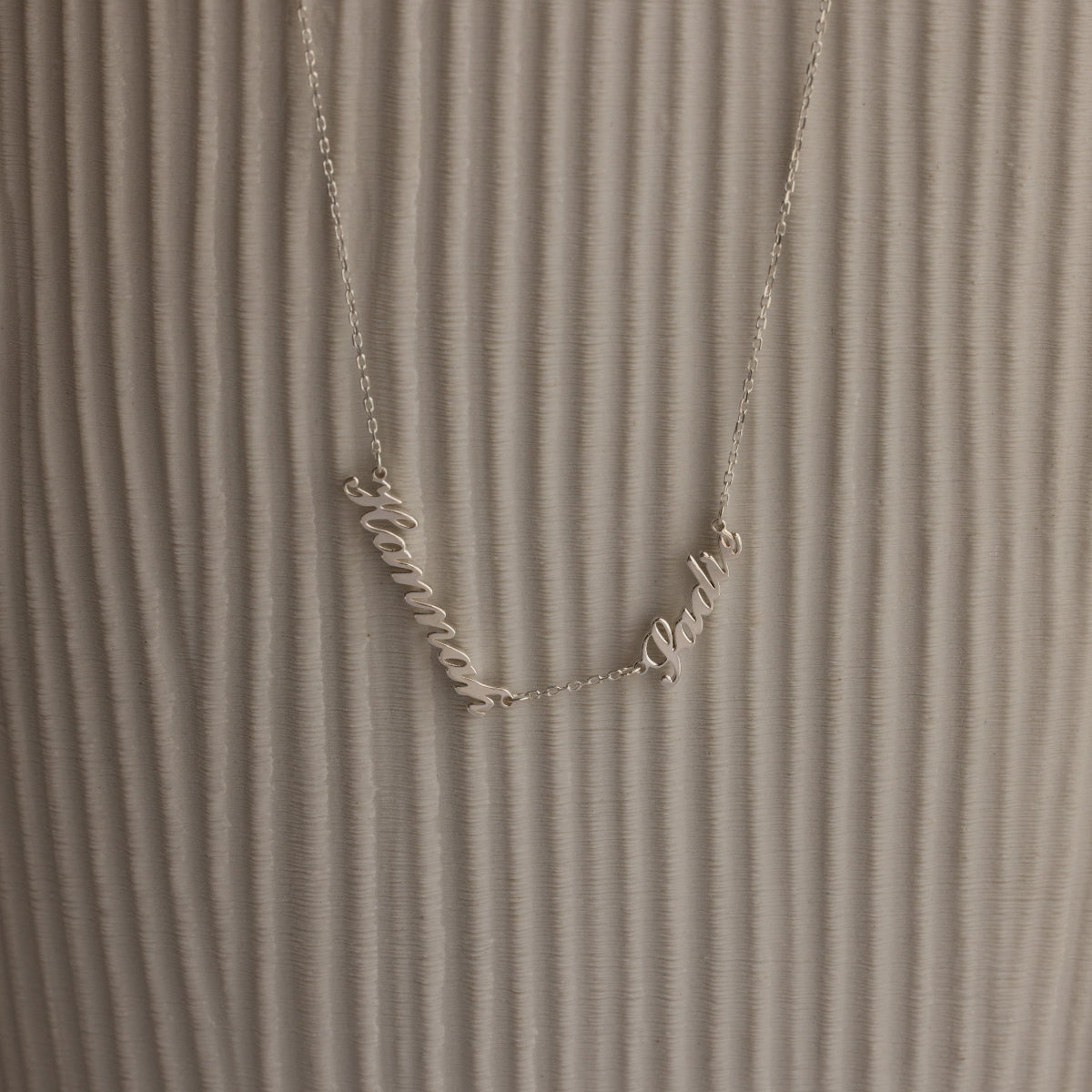 Carrie Multiple Name Necklace with Hanna and Pablo on a textured, light background—a perfect personalized jewelry piece.