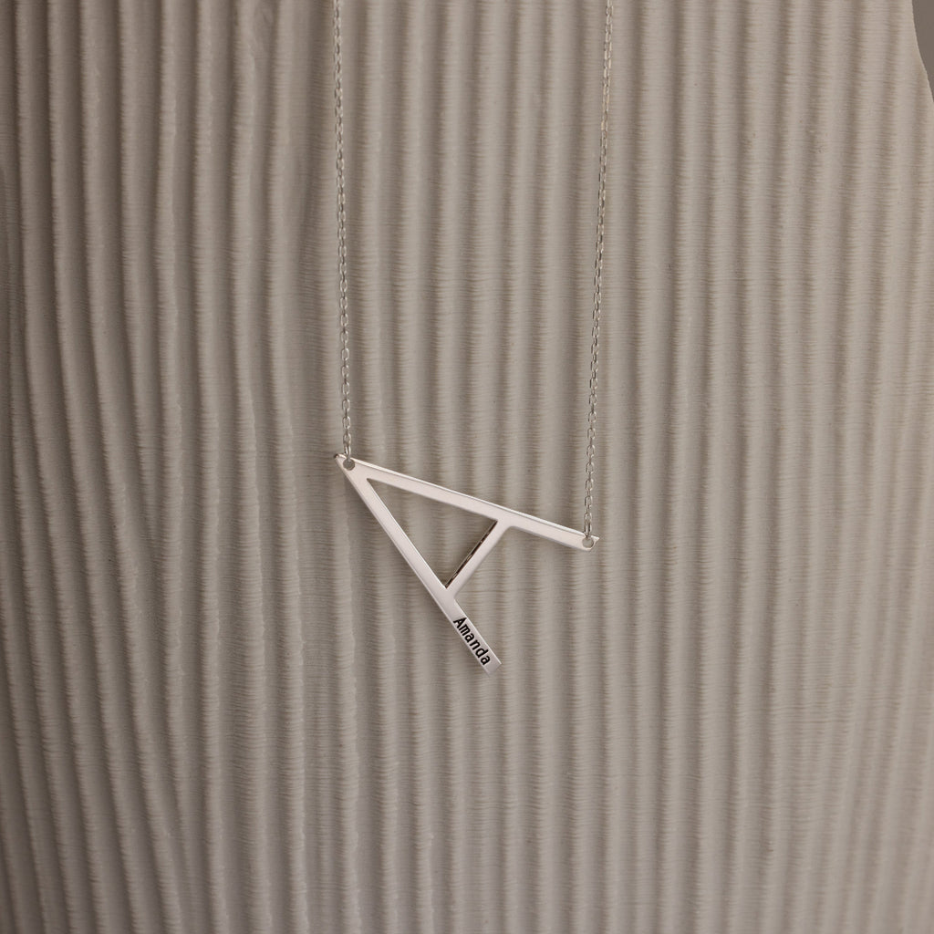 Large Sideways Initial Necklace in Sterling Silver showcased on a textured beige background.