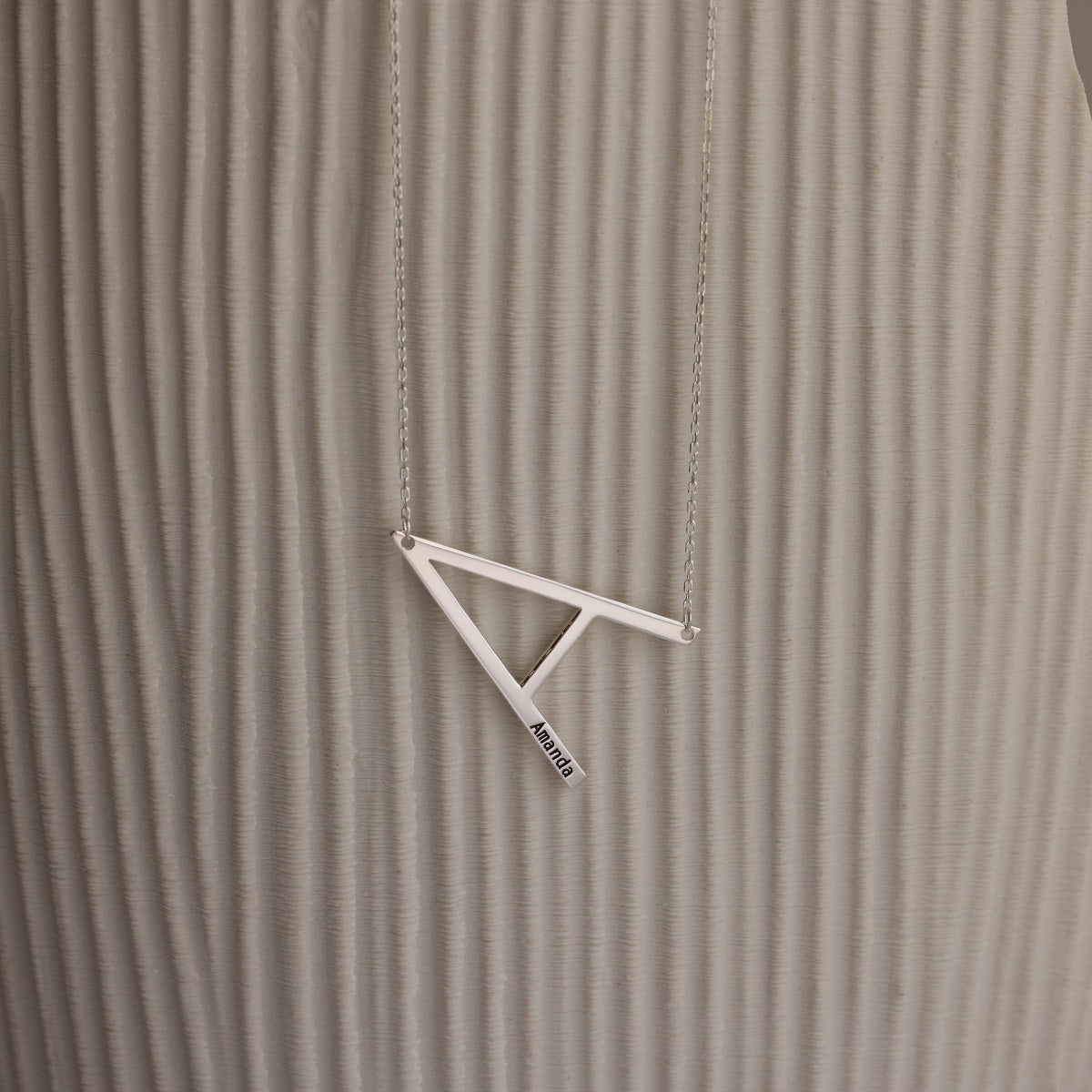 Large Sideways Initial Necklace in Sterling Silver showcased on a textured beige background.