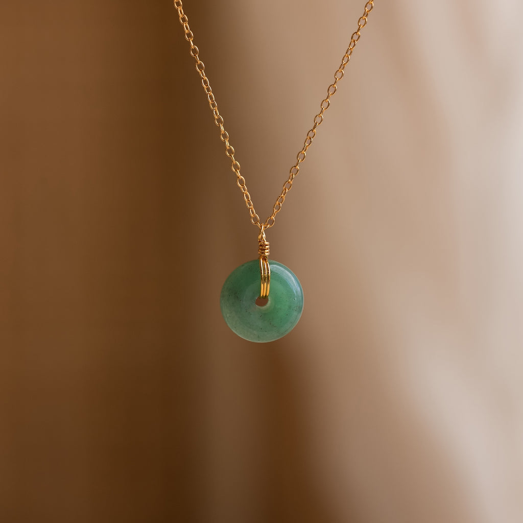 Round Jade Pendant Necklace in 18K Gold displayed against a soft, neutral background.