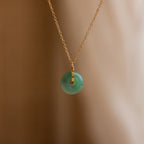 Round Jade Pendant Necklace in 18K Gold displayed against a soft, neutral background.