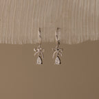 Flatlay of our Teardrop Ribbon Charm Hoops in Silver
