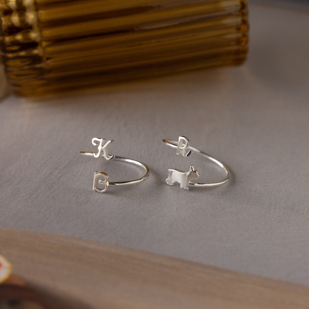 Duo Pet Initial Wrap Ring in Sterling Silver: a set of two rings—one with initials K and C, the other a custom dog-shaped design featuring the letter D.