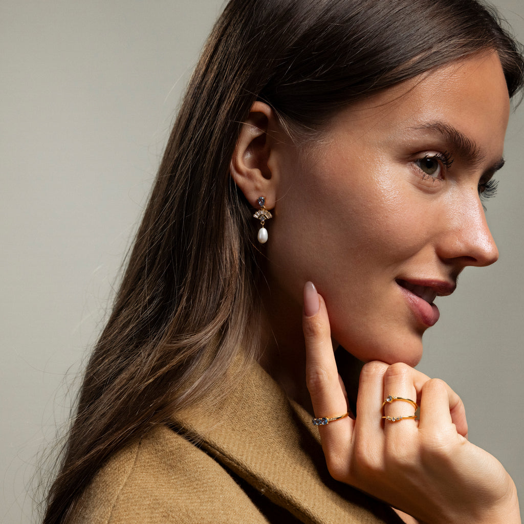 Woman in a brown coat exudes vintage glamour with a gold ring, wedding earrings, and Aquamarine Pearl Drop Earrings in 18K Gold.