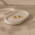 Heart Pearl Drop Earrings in 18K Gold with pearls are displayed on a white oval dish set against a soft beige background.