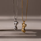 The Kinn Body Necklace features two abstract female torso shaped pendants—one silver, one gold—making a bold statement piece for anyone who loves standout jewelry.