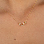 Close-up of a glamorous Pave Linked Pendant Necklace—a gold link chain with a rectangular, diamond-studded pendant—resting elegantly on the neck.