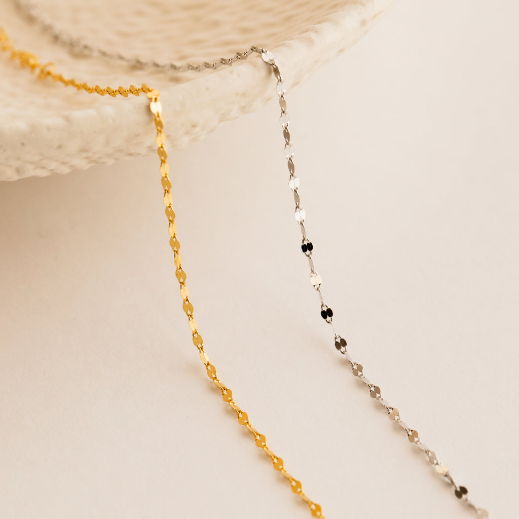 The Josephine Chain Bracelet in Sterling Silver drapes over the edge of a textured white dish on a neutral background.