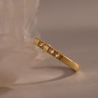 The Diamond Morse Code Ring in 18K Gold features three small diamonds set in a row near a translucent crystal, offering meaningful jewelry that subtly encodes a hidden message.