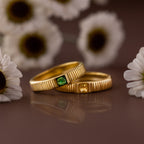 A Ribbed Topaz Band with a square-cut yellow stone, set in a ribbed gold band, is displayed among white daisies.