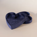 Blue velvet heart-shaped jewelry box with lid, featuring ring slots and compartments on a neutral background.