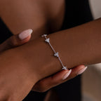 Silver diamond bracelet on a wrist with a blurred background