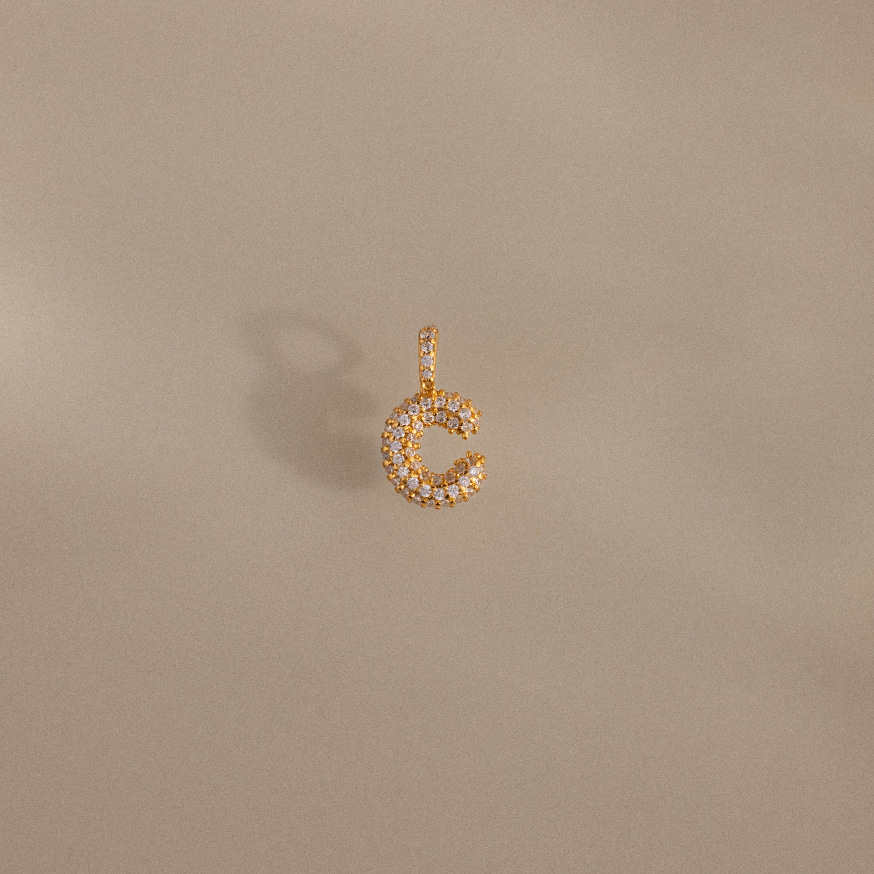 The Pave Bubble Letter Charm features gold and diamonds in a sparkling letter C design—an elegant addition to any collection.
