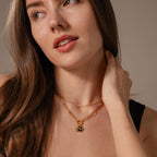 Woman with long brown hair wearing an 18K gold Onyx Honeybee Charm necklace layered over a black top, looking slightly to the side. Perfect for adding elegance and unique style to any outfit.