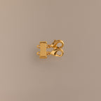 The Double Layering Clasp is a gold multi-strand jewelry clasp with two lobster clasps and three connector rings, perfect for necklace layering and preventing tangling—shown on a beige background.