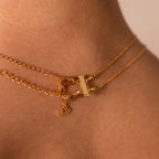 The Double Layering Clasp in 18K Gold secures two delicate chains—a heart and a bar pendant—for effortless necklace layering, creating the perfect jewelry accessory.