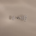 The Triple Layering Clasp in Silver features three loops and a clasp for tangle-free necklace layering, shown on a beige background.