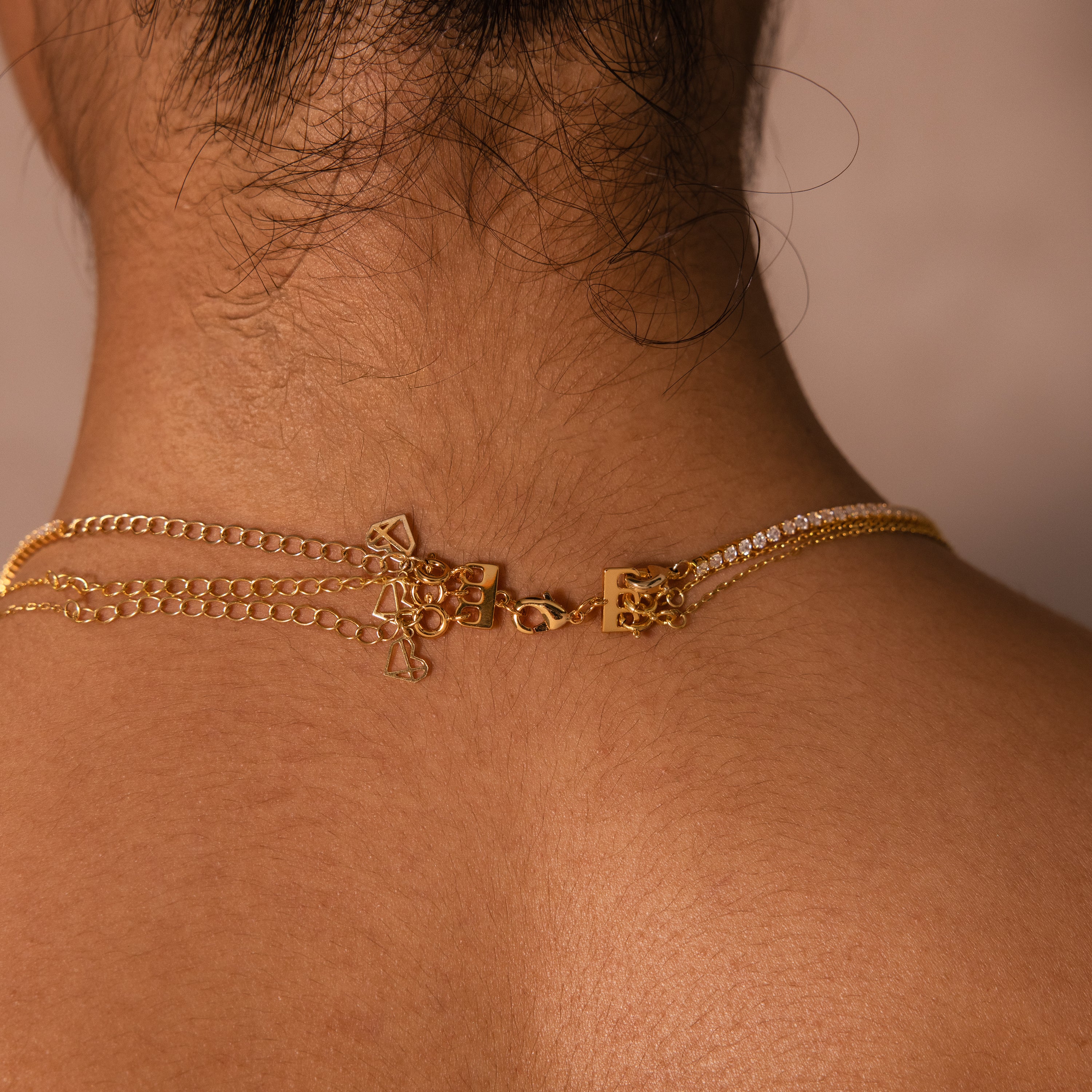 Close-up of a gold necklace clasp fastened on the neck, showing fine chain details—ideal for easy necklace layering with our Triple Layering Clasp in 18K Gold.