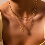 A woman wears a layered gold chain necklace featuring the Pave Dome Charm, paired with a yellow top for a touch of delicate jewelry.