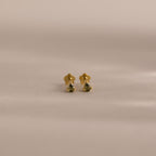 A pair of Teardrop Peridot Flatback Studs, small gold earrings with vibrant peridot stones, perfect as a jewelry gift, displayed on a neutral background.