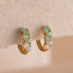 Ombre Opal Huggies: Gold hoop earrings featuring oval opal stones, ideal for fans of elegant opal jewelry.