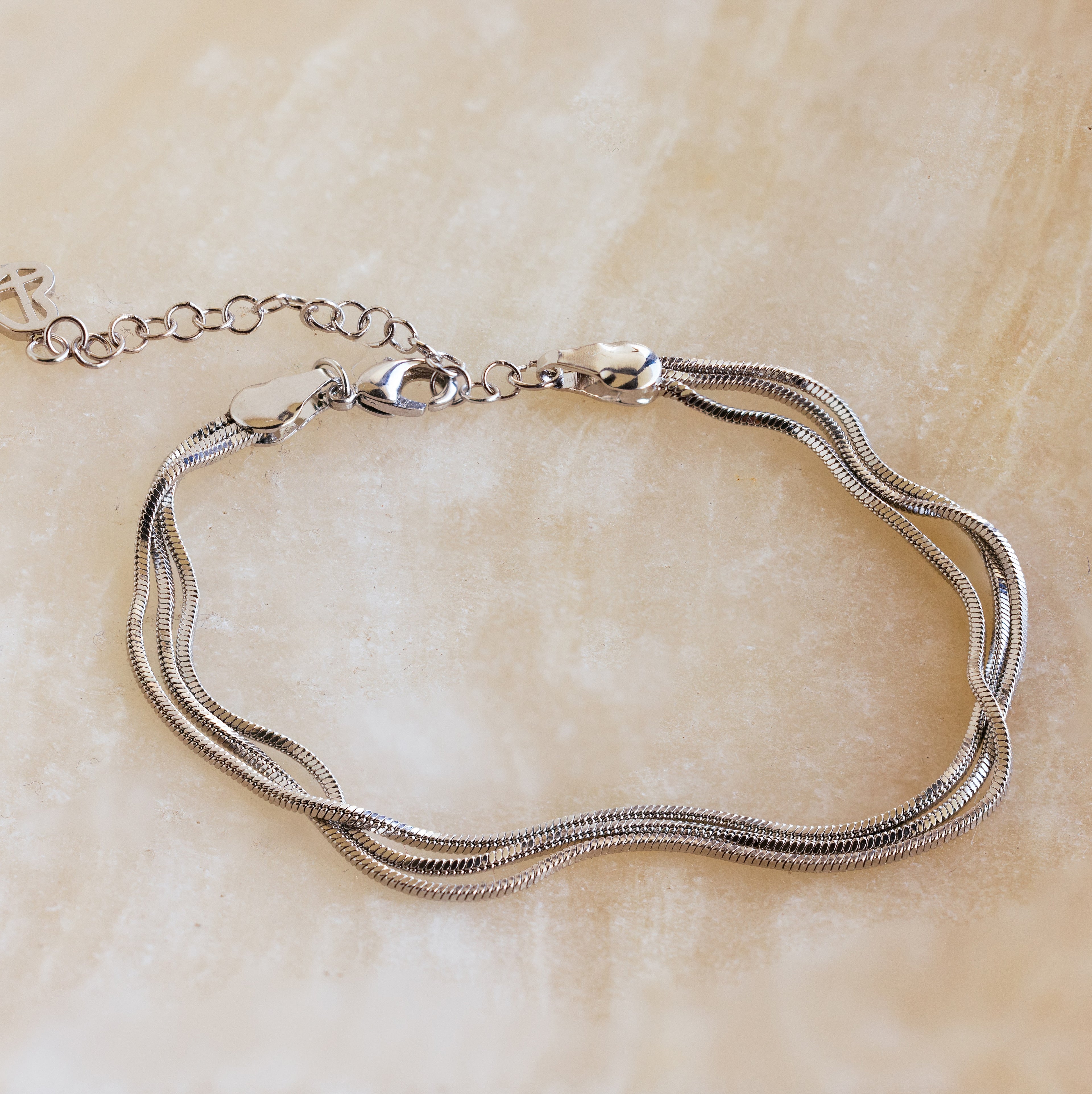 A minimal jewelry piece, the Triple Snake Chain Bracelet features a lobster clasp and adjustable links, perfect for a layered look.