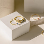 Gold rings with gemstones on a white surface