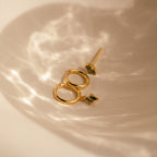 The Peridot Earrings Set in 18K Gold is displayed in a softly lit, neutral dish—ideal for stacking or as a chic cartilage earring.