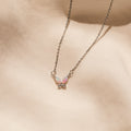 Pink Opal Butterfly Necklace in Silver, featuring a delicate butterfly charm, showcased on a soft beige fabric background.