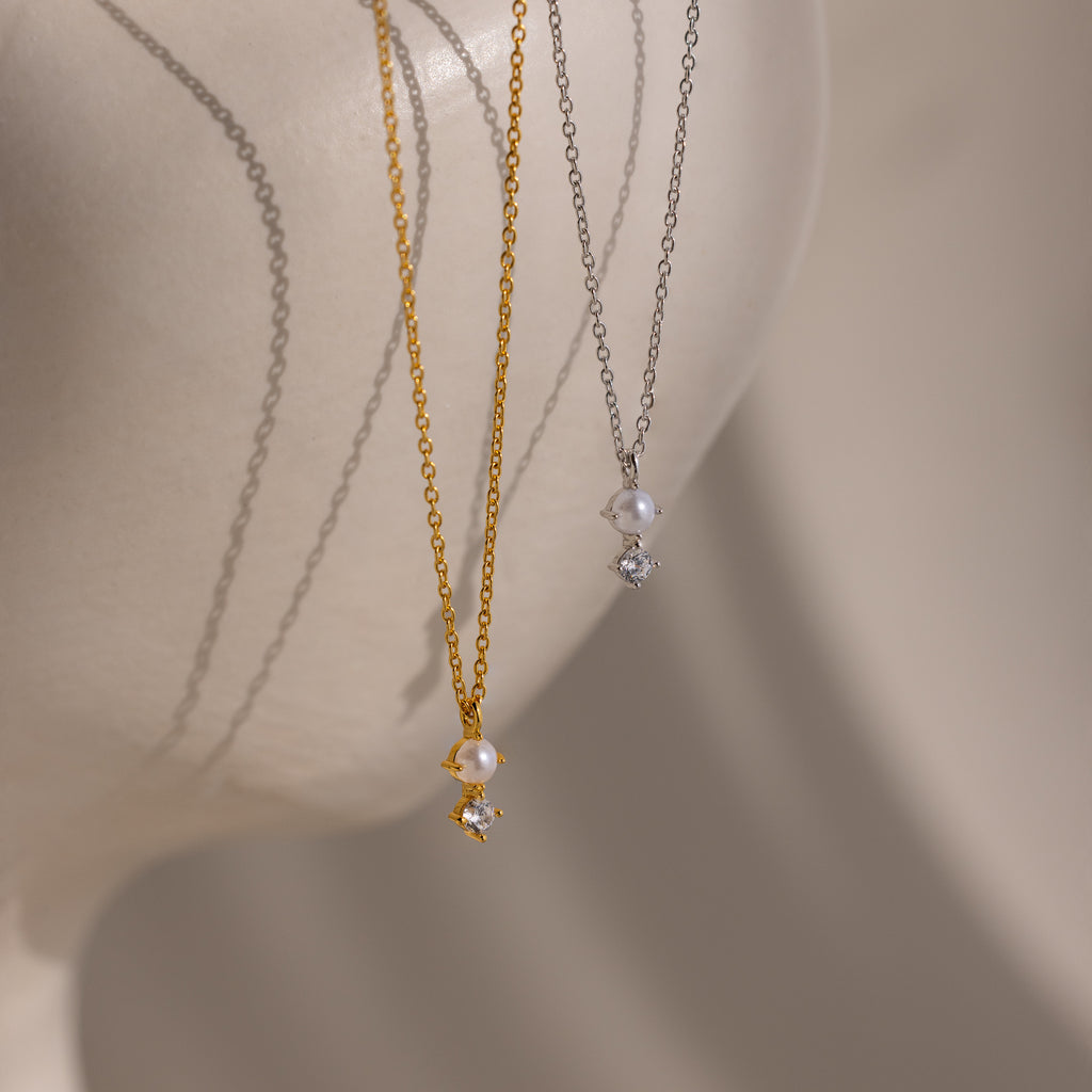 The Pearl Diamond Drop Necklace in Silver, ideal bridal jewelry, is displayed on a smooth, light-toned mannequin bust.