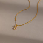 The Pearl Diamond Drop Necklace in 18K Gold features a small pearl and diamond pendant, perfect for bridal jewelry, shown on a neutral background.