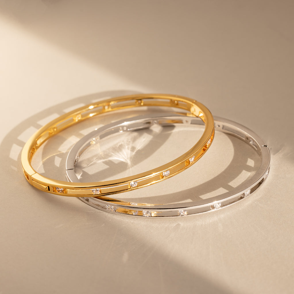 The Lace Diamond Bangle in Sterling Silver features an elegant open station design with sparkling round diamonds, adding a touch of sophistication to any look.