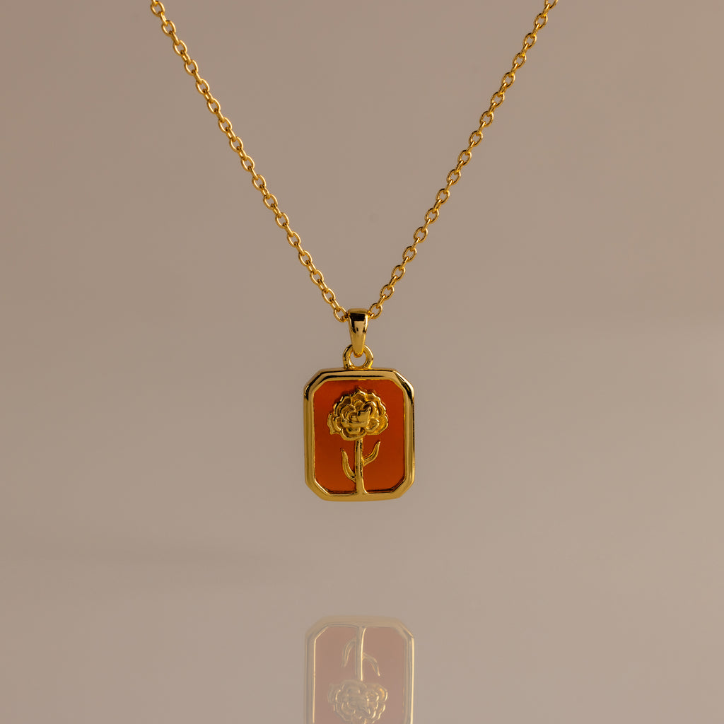 Garnet Birth Flower Charm Necklace featuring a rectangular pendant with an engraved flower design on an orange background.