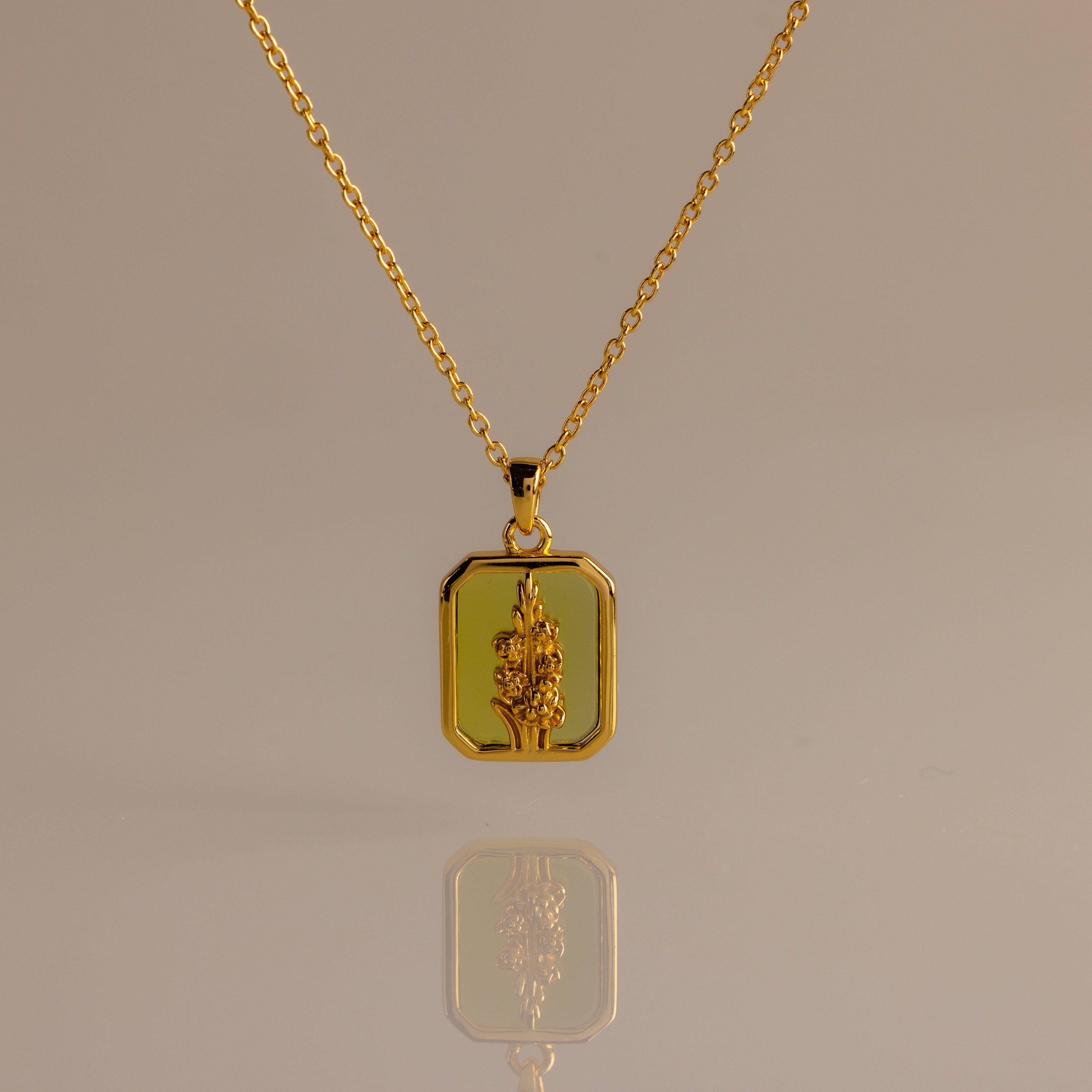 Peridot Birth Flower Charm Necklace with a rectangular pendant and raised floral design, ideal for elegant jewelry lovers and gift ideas, shown on a neutral background.