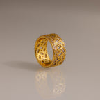 Bold and eye-catching, the Mosaic Diamond Baguette Ring features a wide gold band with a geometric lattice pattern and small embedded diamonds set against a plain background.