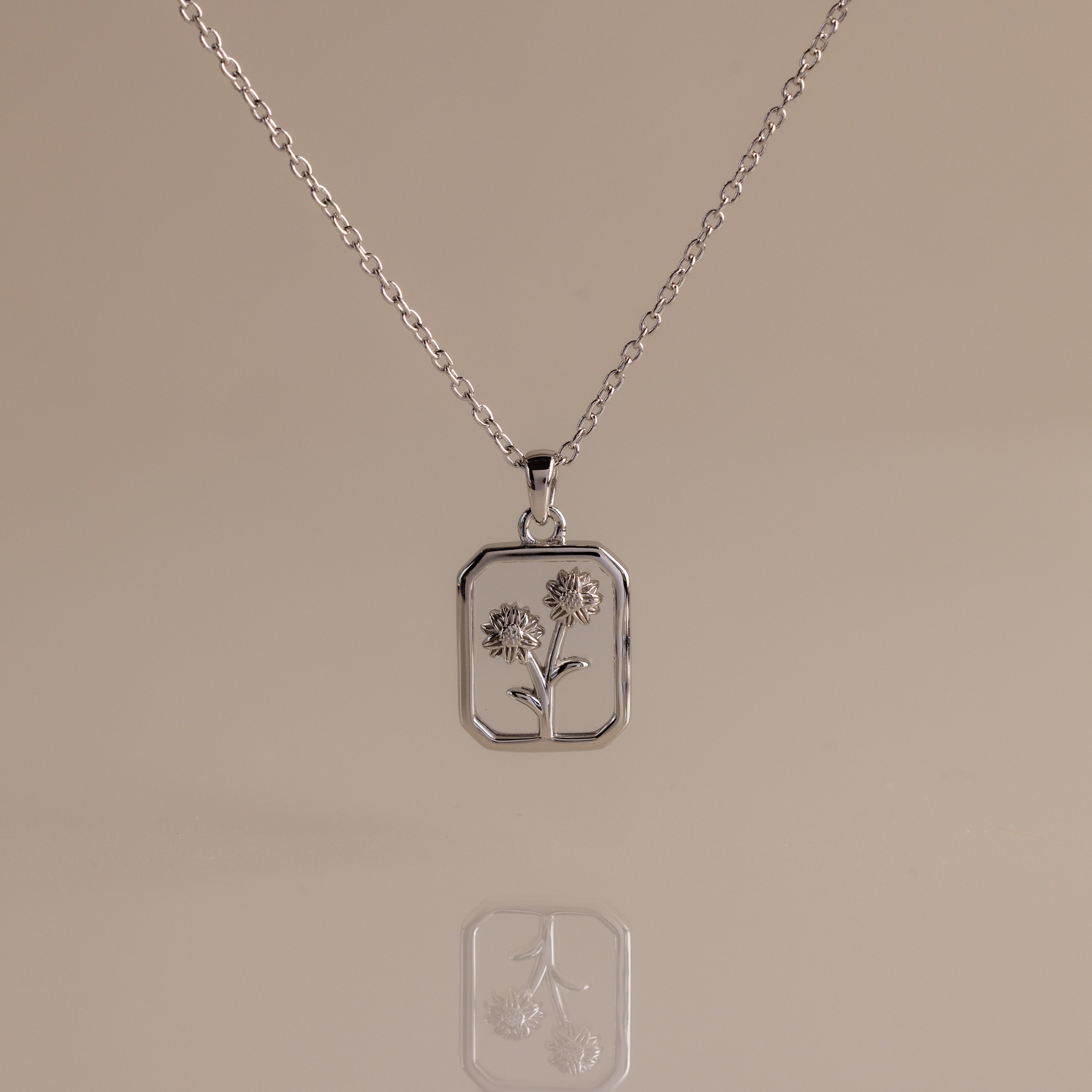 Diamond Birth Flower Charm Necklace with a rectangular pendant showcasing two outlined flowers on a neutral background—ideal for adding subtle floral elegance to any outfit.