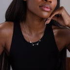 A woman in a black tank top wears the Alice Letter Name Necklace in Sterling Silver, customized with "MAMA"—a perfect Christmas gift.
